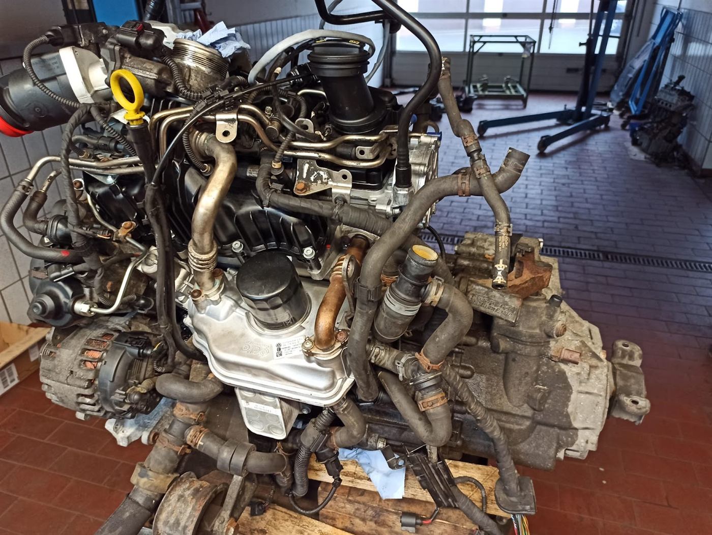 Ausgebauter Motor mit Getriebe auf einer Palette in der Werkstatt von Auto Scharrer