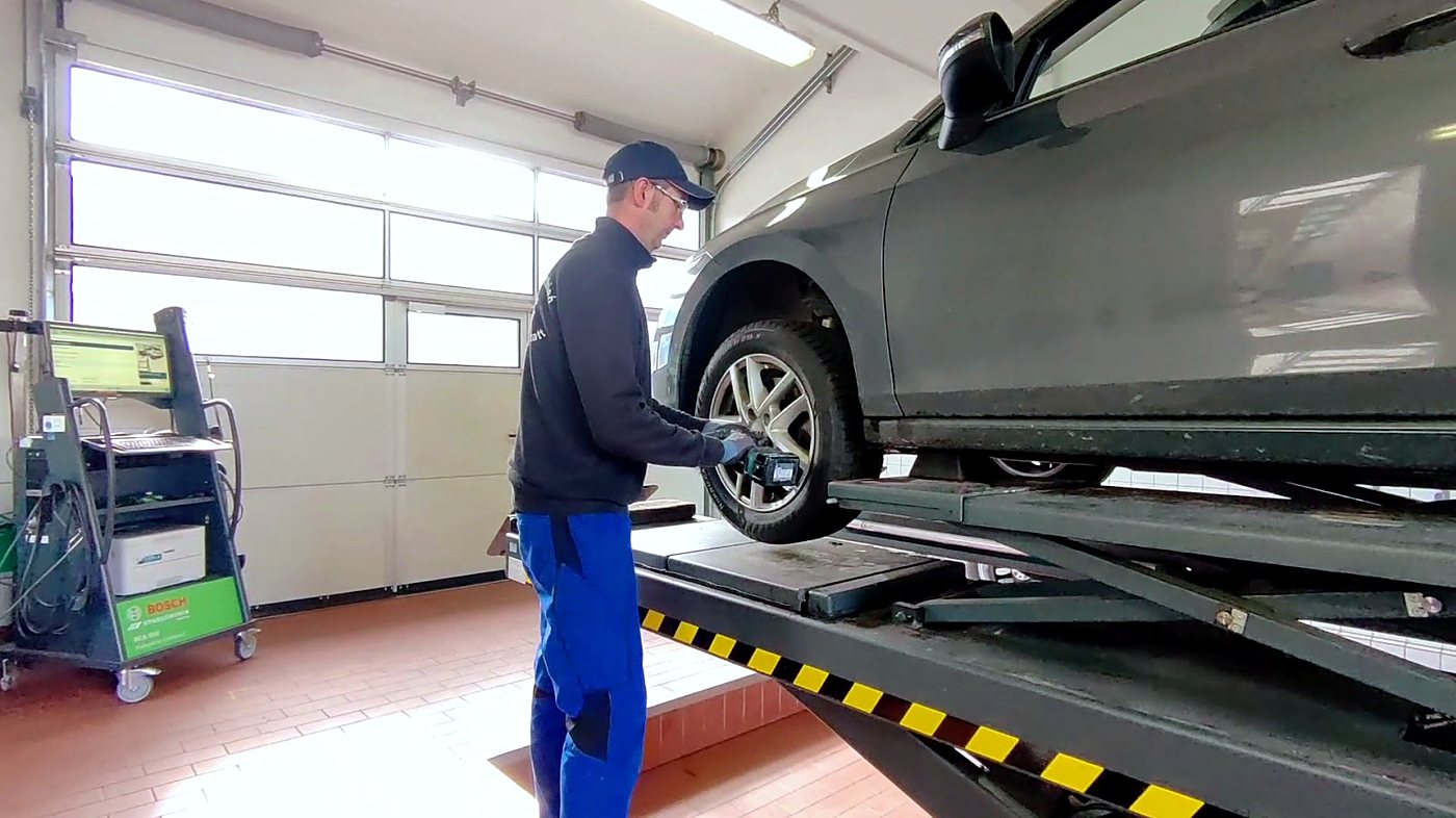 Mechaniker von Auto Scharrer beim Radwechsel an einem Fahrzeug auf der Hebebühne